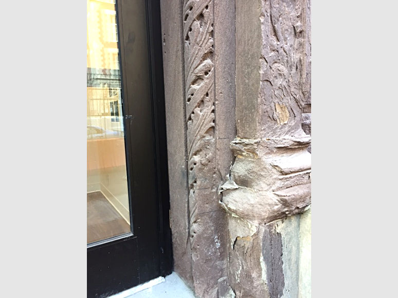 building entrance with damaged and worn stonework